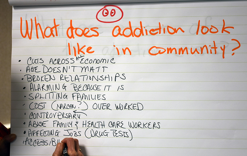 A community member in Belpre takes notes on what addiction looks like there
