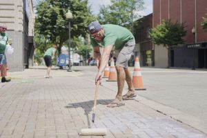 Plant Portsmouth volunteer washes the sidewalk