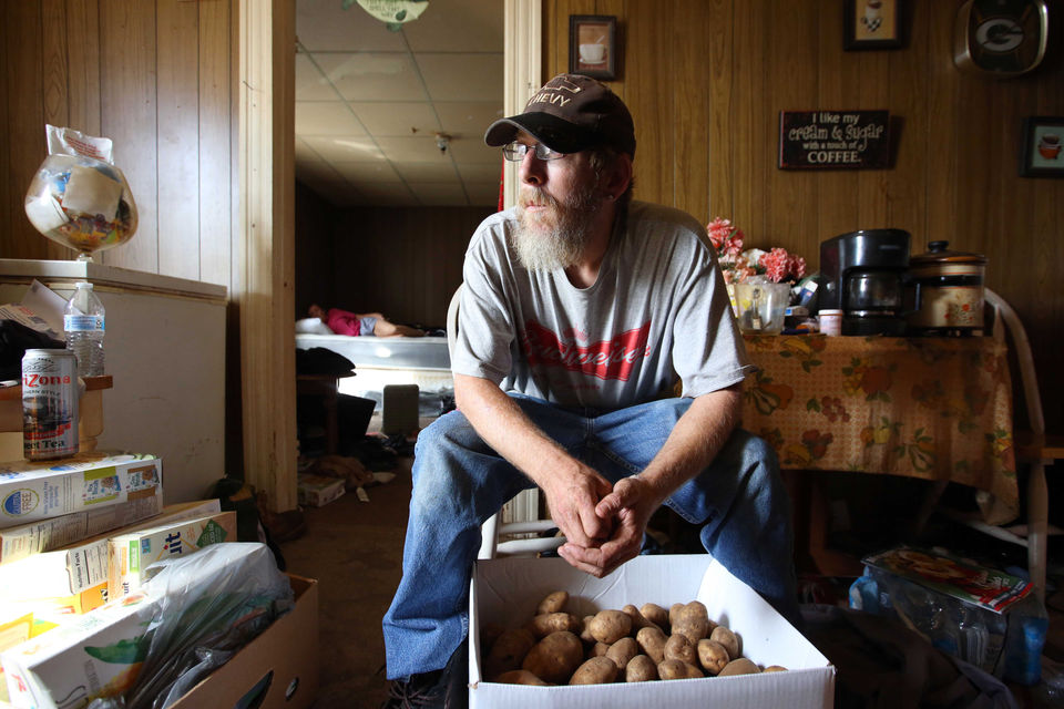 James McIntire sits among boxes of food from a local food pantry.