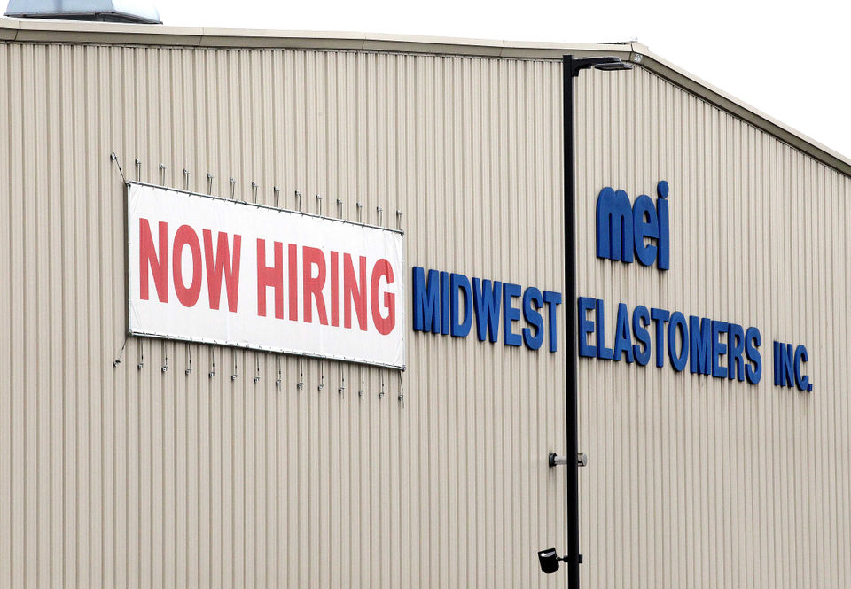 Now hiring sign on the front of a warehouse.