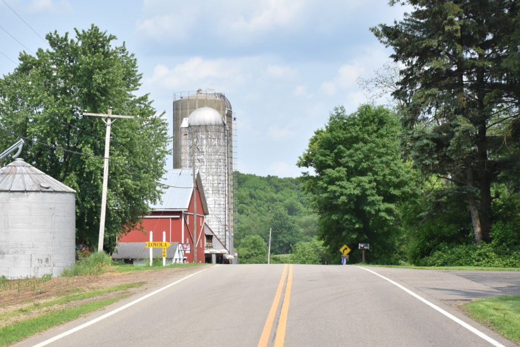 Street view of a barn and grain silo.