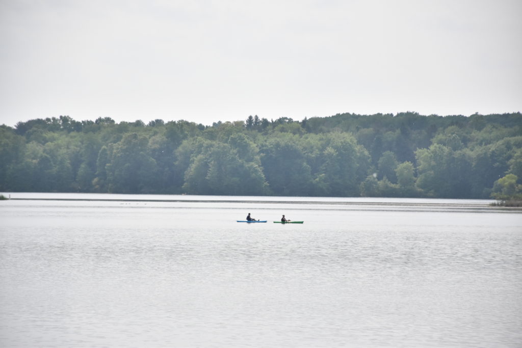 Two people canoeing on a large lake.