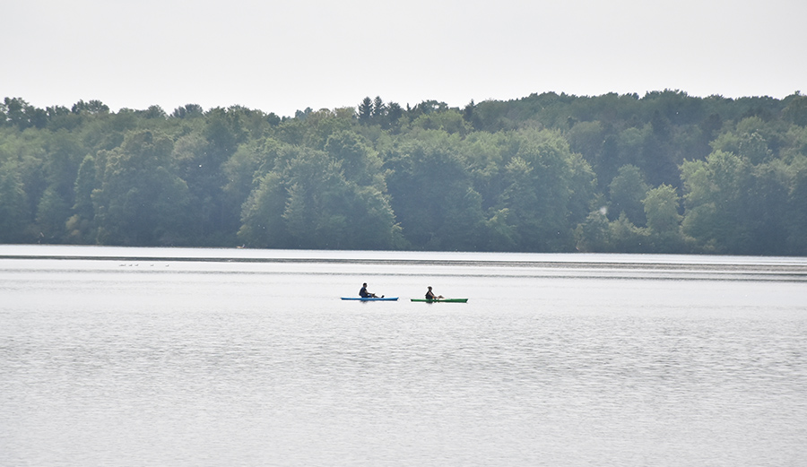 Two people canoeing on a large lake